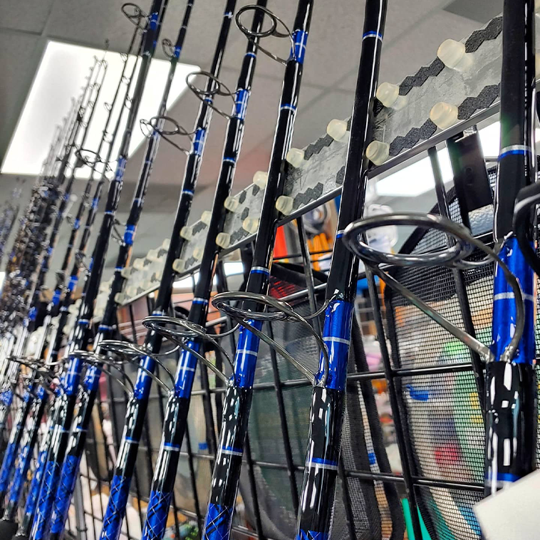 Image of many chaos rods line dup in a display rack in the store. The rods are blue and black, mostly spinners.