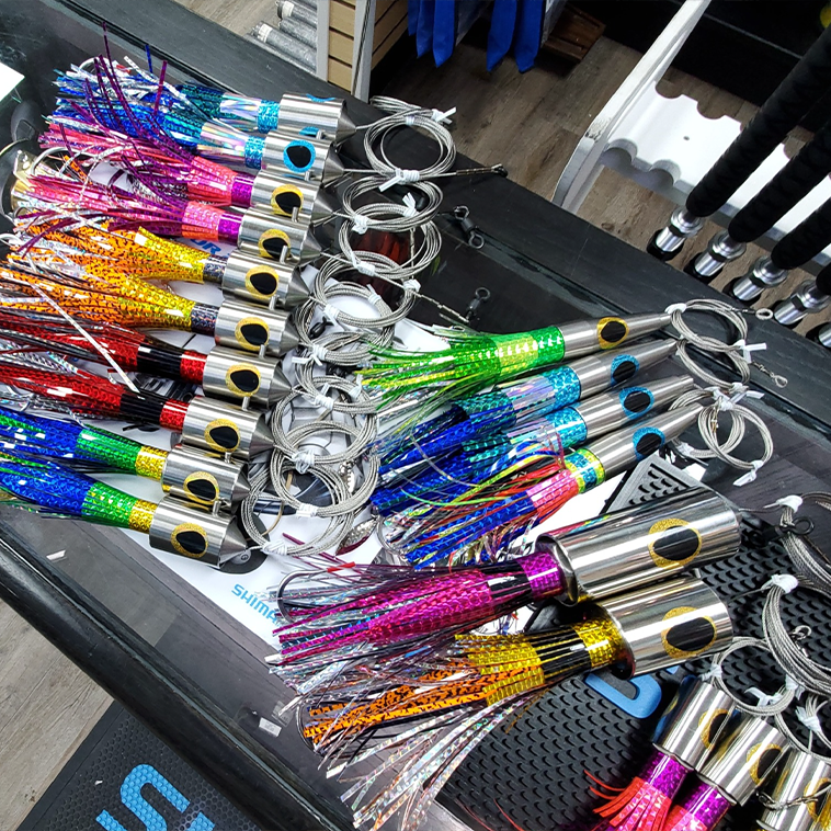 Vibrant fishing lures on the counter, many are rigged and ready to go