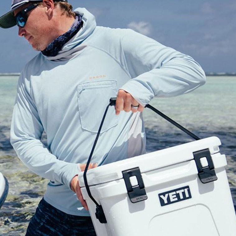Person carrying a yeti cooler to represent that CHAOS sells accessories for fishing.
