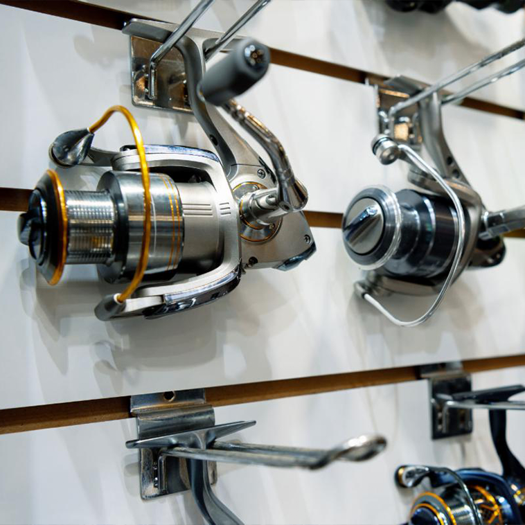 several fishing reels hanging on a display